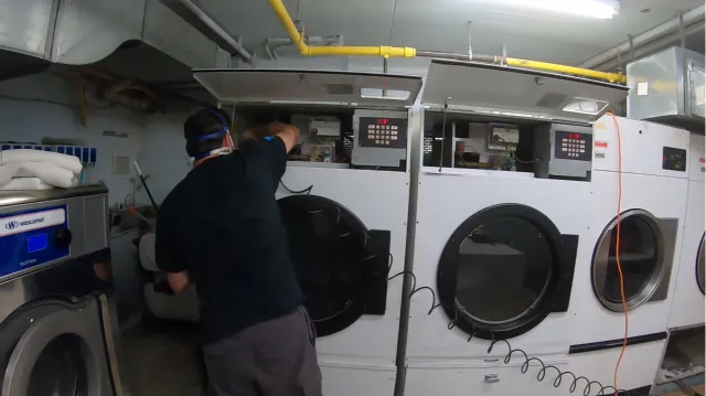 Bright commercial laundry room with a row of washing machines