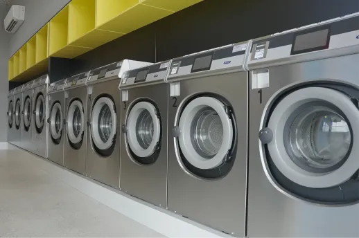 Close-up of a commercial washing machine drum and door filled with water